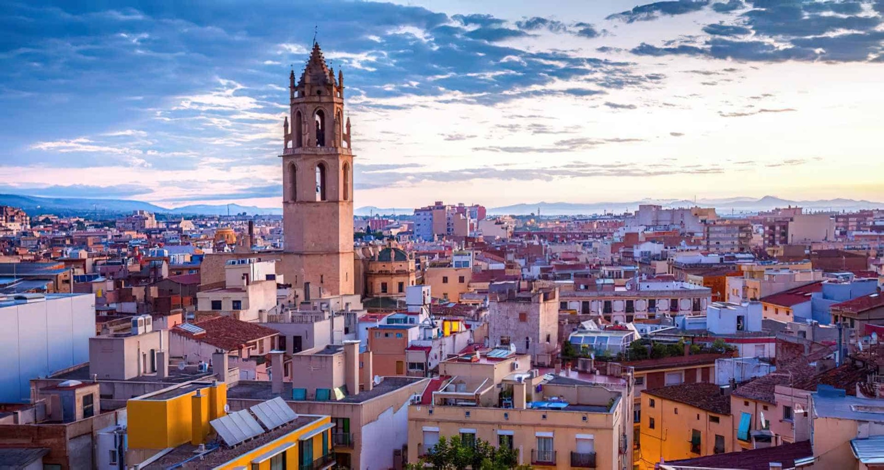 Vista panorámica de Reus al atardecer con el campanario de la iglesia prioral de Sant Pere.