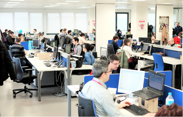 Equip de persones treballant a les oficines de les instal·lacions de REDESSA Tecno en taules.